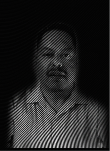 Black and white portrait of a man with a mustache in a collared shirt, shown through curved lines that create a textured, optical effect—perfect for marketing visuals or SEO-focused campaigns seeking striking, memorable imagery.