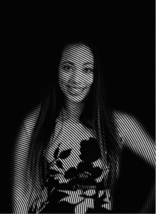 A woman with long hair stands against a dark background, her image rendered in black and white with curved, parallel lines—an effect as striking as successful search engine optimization in digital marketing.