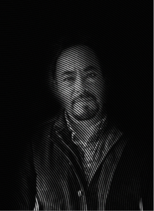 A man with a beard and mustache is shown in low light, with circular lines creating a textured overlay on the image, evoking the layered complexity of search engine optimization.