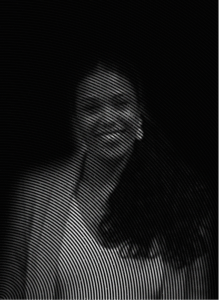 A woman is smiling at the camera with wavy, circular lines overlaying the black-and-white image, creating a distorted visual effect that evokes the dynamic flow of digital marketing strategies.