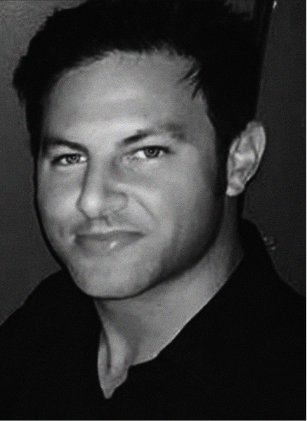 Black and white portrait of a man with short dark hair, light eyes, and a slight smile, wearing a dark collared shirt—ideal for a professional SEO or CRM profile facing the camera.