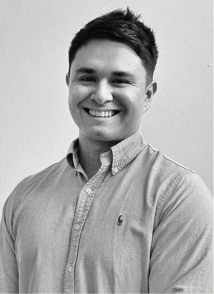 A man with short dark hair, wearing a light-colored button-up shirt, is smiling at the camera against a plain background, reflecting confidence in digital marketing and SEO expertise.