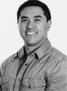 A man with short dark hair wearing a button-up shirt smiles at the camera against a plain background, reflecting confidence in email marketing.