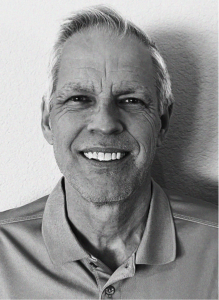 Black and white portrait of an older man with short hair, smiling in a collared shirt, against a plain background—perfect for marketing or search engine optimization profiles.