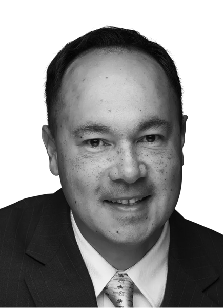 Black and white headshot of a man in a suit and tie, smiling slightly, facing the camera against a plain background—a confident professional in digital marketing.