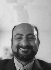 A man with a beard and mustache, dressed in a suit and tie, smiles at the camera in a black-and-white photo—reflecting the professionalism often seen in SEO or CRM industry portraits.
