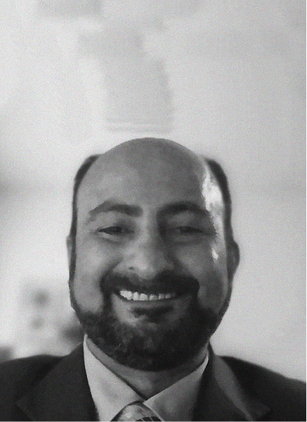 A man with a beard and mustache, dressed in a suit and tie, smiles at the camera in a black-and-white photo—reflecting the professionalism often seen in SEO or CRM industry portraits.