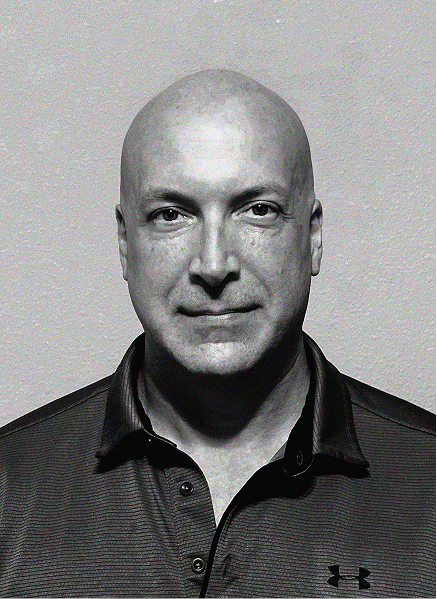 Black and white portrait of a bald man in a collared Under Armour shirt, looking directly at the camera against a plain background—ideal for digital marketing or CRM professional profiles.
