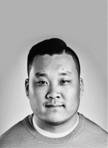 Black and white portrait of a man with short dark hair, wearing a crew-neck sweater, looking directly at the camera against a plain background—a modern look fit for any email marketing or digital marketing professional.