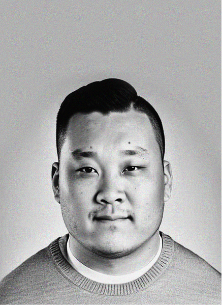 Black and white portrait of a man with short dark hair, wearing a crew-neck sweater, looking directly at the camera against a plain background—a modern look fit for any email marketing or digital marketing professional.