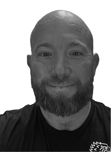 A bearded man with a bald head smiles slightly, facing forward, dressed in a dark shirt. The plain, light-colored background gives him a professional look suitable for digital marketing or CRM profiles.