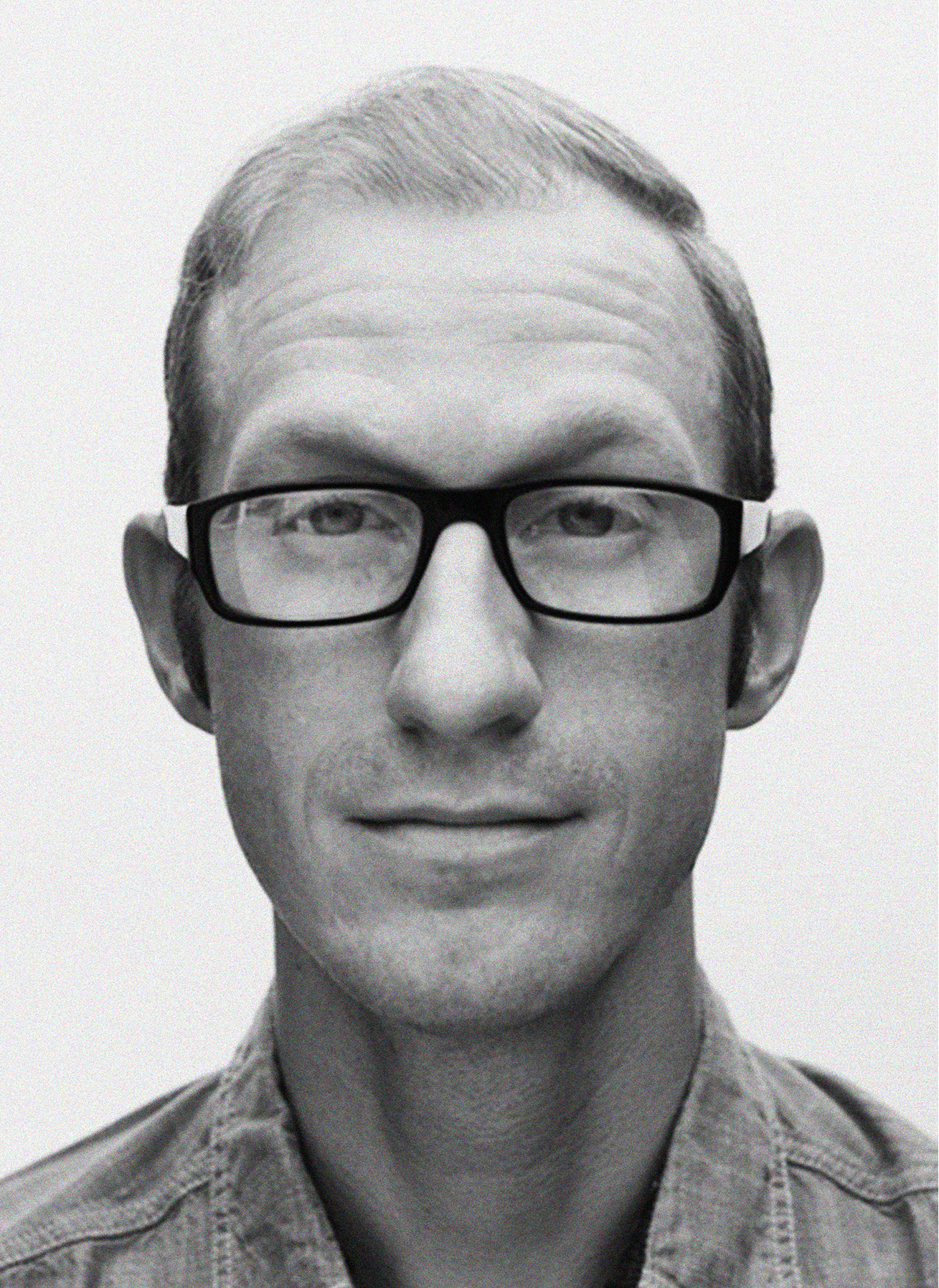 A man with short, light hair wearing black glasses and a button-up shirt looks directly at the camera against a plain background—perfect for showcasing digital marketing or CRM expertise.