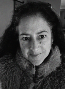 Black and white close-up of a person with long dark hair, wearing a fur-collared jacket and looking directly at the camera, evoking the bold focus needed for standout marketing or impactful email marketing campaigns.