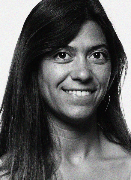 Black and white portrait of a woman with long hair, smiling slightly and looking directly at the camera against a plain background, capturing the confidence of a marketing professional.